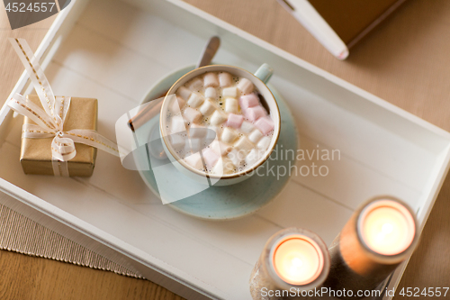 Image of hot chocolate, christmas gift and candles on table