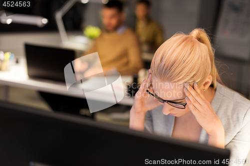 Image of stressed businesswoman working at night office