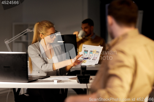 Image of workers with user interface mockup at night office