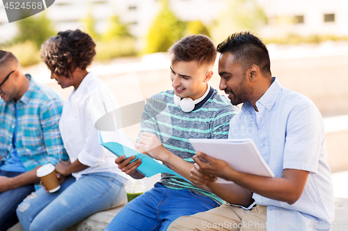 Image of international students with notebooks outdoors