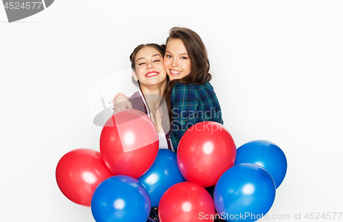 Image of happy teenage girls with helium balloons