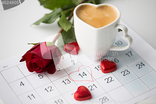 Image of close up of calendar, hearts, coffee and red rose