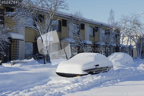 Image of cars covered in snow near the house