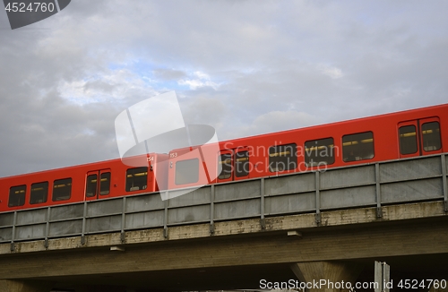 Image of red subway cars on a overpass