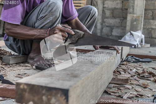 Image of Close up of warn hands of carpenter working in traditional manual carpentry shop in a third world country.