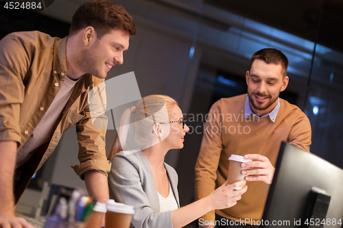 Image of business team with coffee working at night office