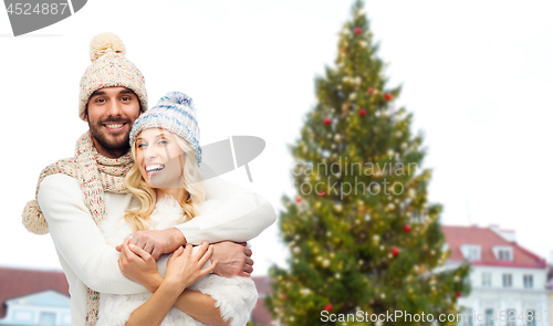 Image of happy couple hugging over christmas tree