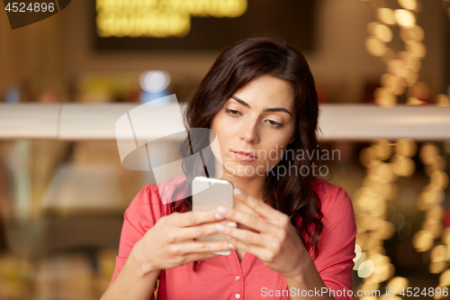 Image of woman with smartphone at restaurant
