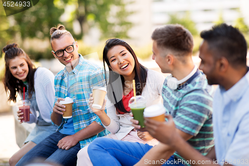 Image of friends drinking coffee and juice talking in city