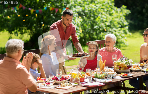 Image of happy family having dinner or summer garden party