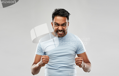 Image of angry indian man screaming over grey background