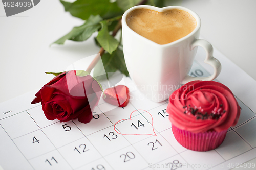 Image of close up of calendar, coffee, cupcake and red rose