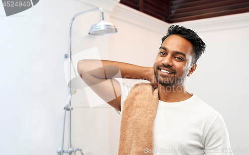 Image of smiling indian man with bath towel over shower