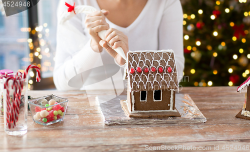 Image of woman making gingerbread houses on christmas