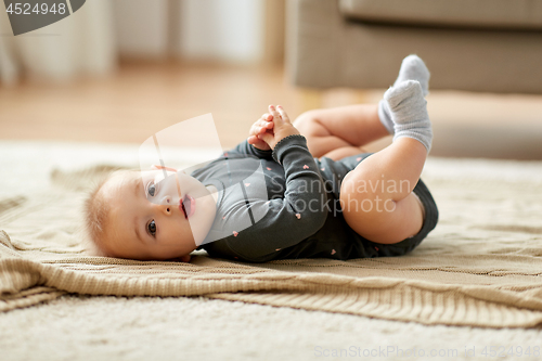 Image of lovely baby girl lying on floor at home