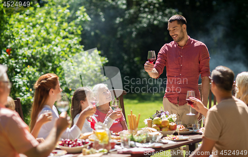 Image of happy family having dinner or summer garden party