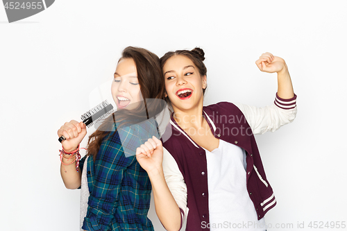 Image of teenage girls singing to hairbrush and having fun