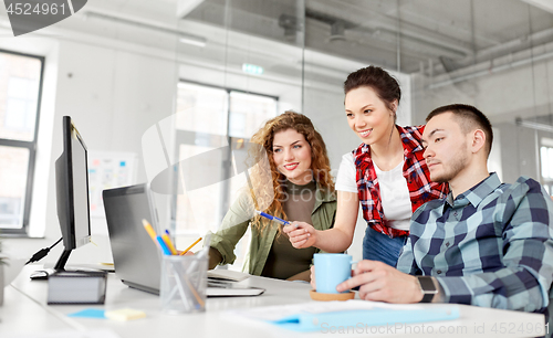 Image of creative team with laptop working at office