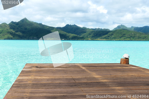 Image of wooden pier on tropical beach in french polynesia