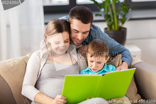 Image of happy family reading book at home