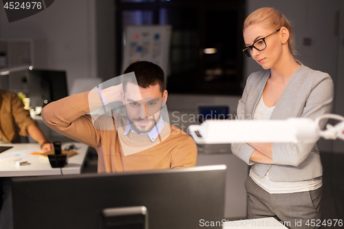 Image of business team with computer working late at office