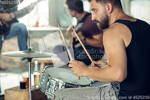 Image of Repetition of rock music band. Electric guitar player and drummer behind the drum set.