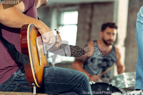 Image of Repetition of rock music band. Electric guitar player and drummer behind the drum set.