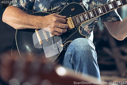 Image of Repetition of rock music band. Electric guitar player and drummer behind the drum set.