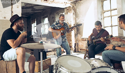 Image of Repetition of rock music band. Electric guitar player and drummer behind the drum set.