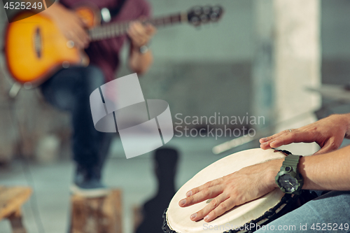 Image of Repetition of rock music band. Electric guitar player and drummer behind the drum set.