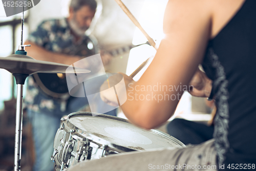 Image of Repetition of rock music band. Electric guitar player and drummer behind the drum set.