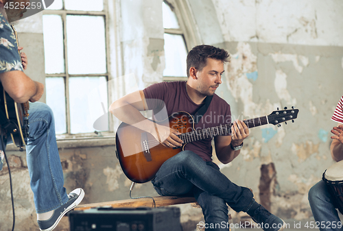 Image of Repetition of rock music band. Electric guitar player and drummer behind the drum set.