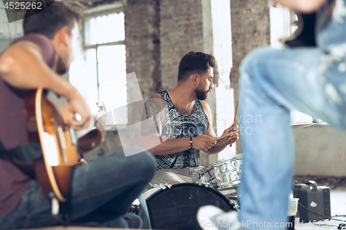 Image of Repetition of rock music band. Electric guitar player and drummer behind the drum set.