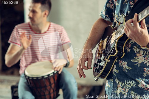 Image of Repetition of rock music band. Electric guitar player and drummer