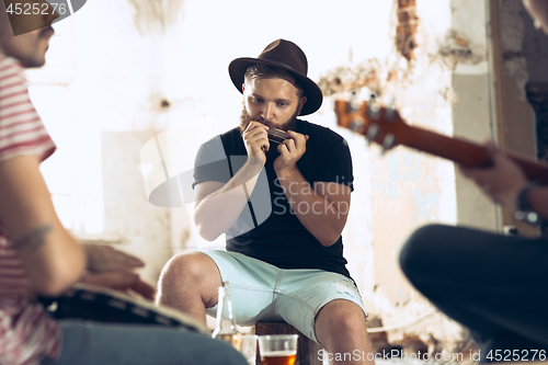 Image of Repetition of rock music band. Electric guitar player and drummer behind the drum set.