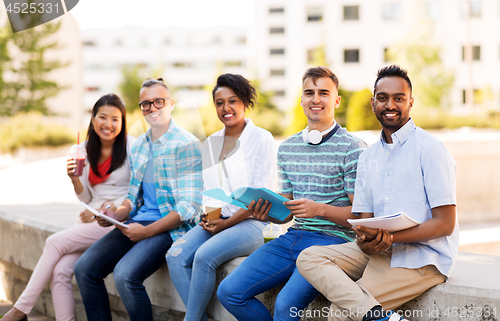 Image of students with notebook and takeaway drinks