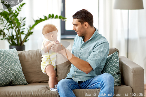 Image of father with little baby daughter at home