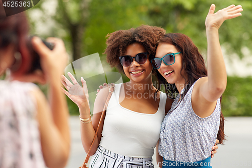 Image of woman photographing her friends in summer