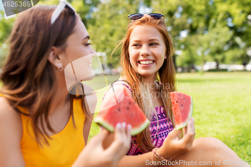 Image of teenage girls eating watermelon at picnic in park