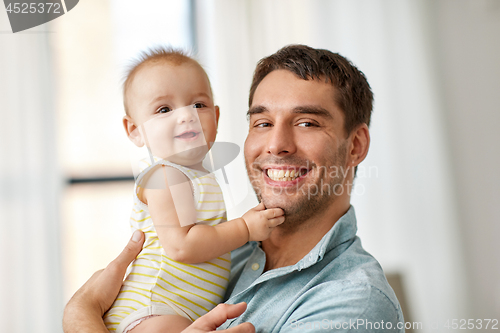 Image of happy father holding little baby daughter at home