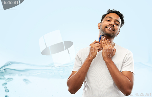 Image of indian man shaving beard with razor blade