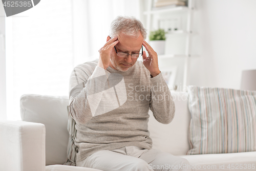 Image of senior man suffering from headache at home