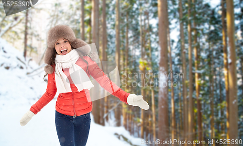 Image of happy woman in fur hat over winter forest