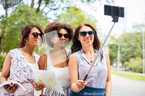 Image of women with city guide and map taking selfie