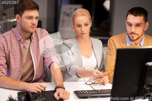 Image of business team with computer working late at office