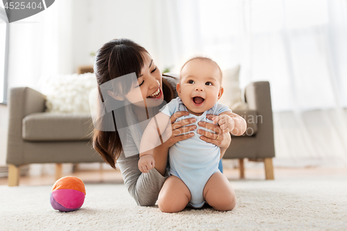 Image of happy young mother with little baby at home