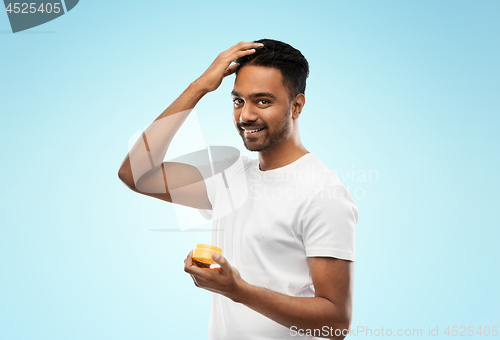 Image of indian man applying hair wax or styling gel