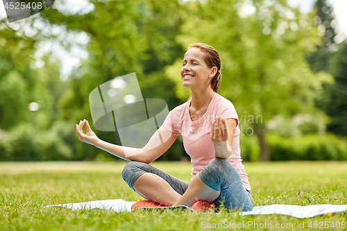 Image of happy woman meditating in summer park