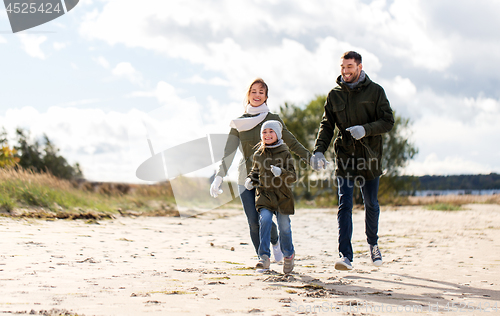 Image of happy family running along autumn beach