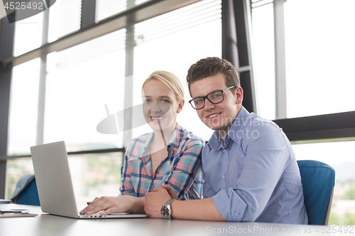 Image of Two Business People Working With laptop in office